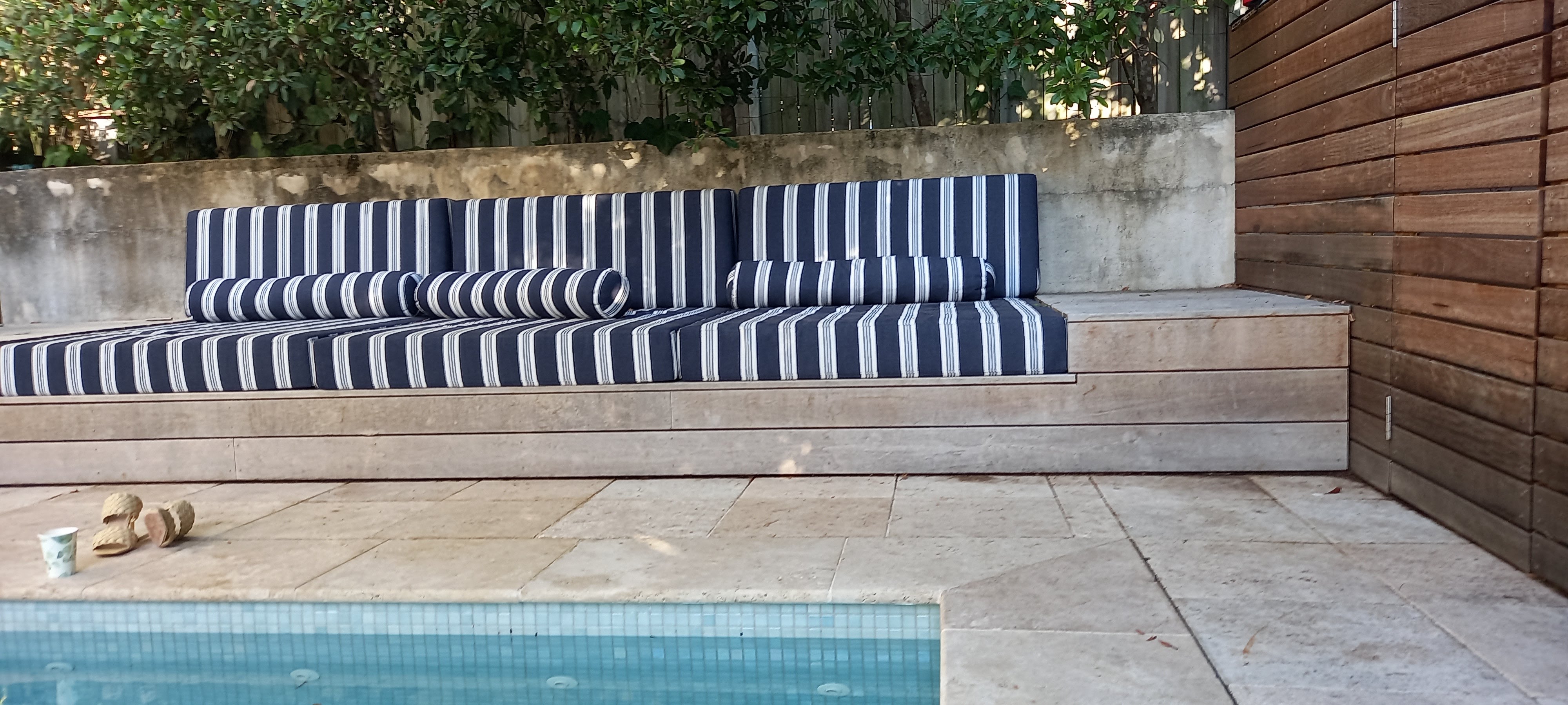 Outdoor entertaining area with paved flooring beside a pool